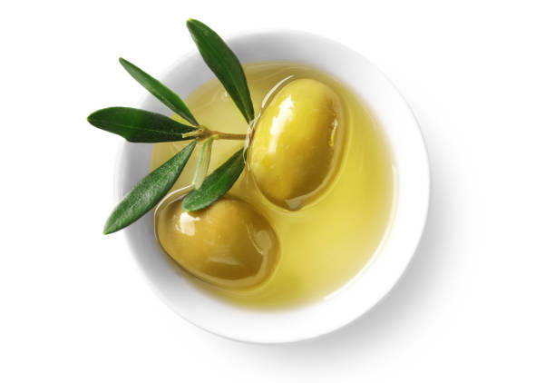istock Olive branch and olive oil in a bowl isolated on white. Top view 1347207985