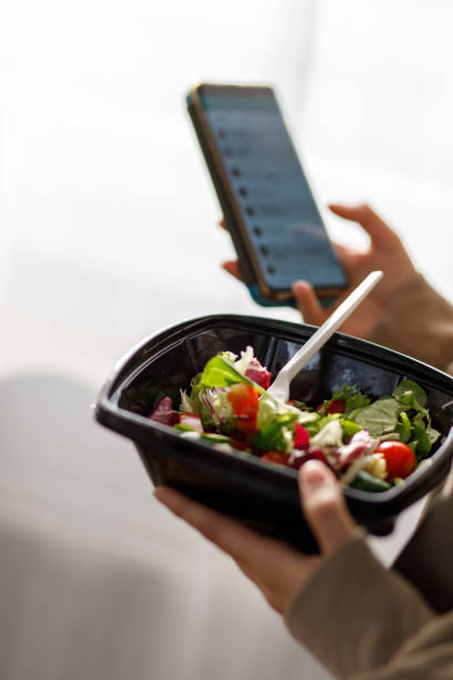 istock Young woman using a food delivery app to confirm her order 1347208357