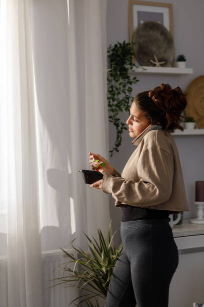 istock Young talking on the phone and eating takeaway 1347208366