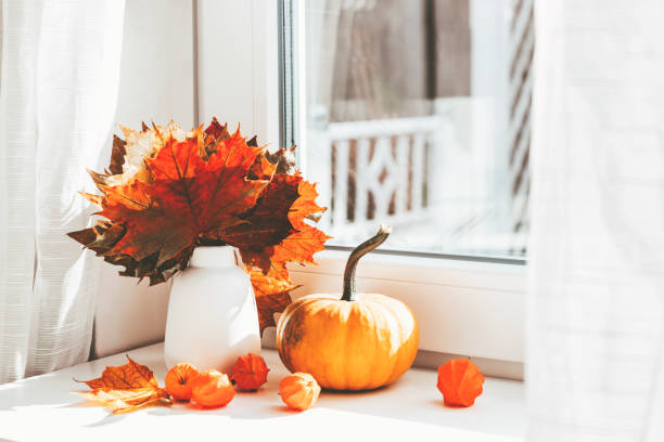 istock Autumn home decoration on the window using dry leaves and pumpkin 1347209295