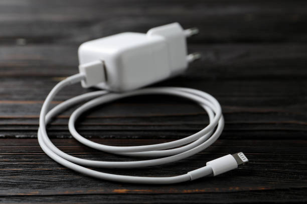 istock White charging cable and adapter on black wooden table 1347209691
