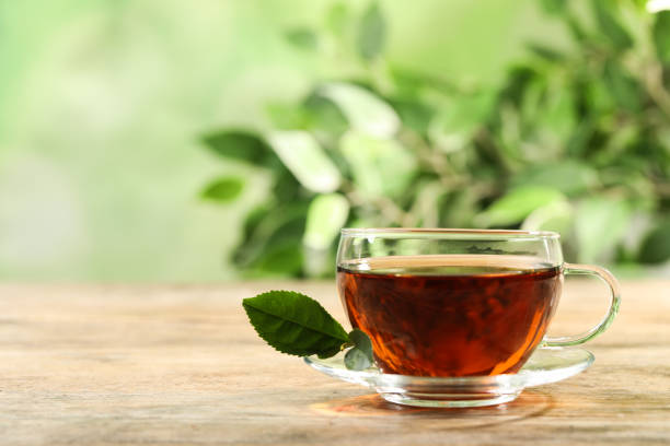 istock Cup of black tea on wooden table against blurred background. Space for text 1347212505