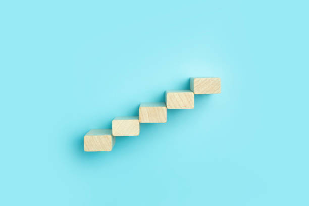 istock Business growth, development plan concept and business analytics background. Wooden steps of blocks on a blue background as financial and career growth, increase in monetary income and economic development. 1347212615