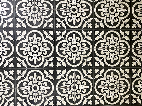 Horizontal close up of large patterned black and white ceramic floor tiles