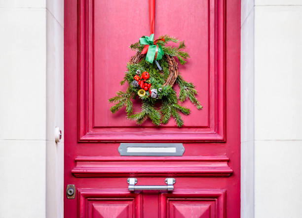 istock A Christmas crown hanging on a red front door with moldings. 1347215073