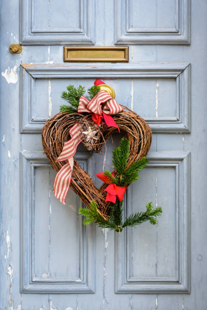 istock A heart-shape Christmas decoration hanging on a worn front door. 1347215990