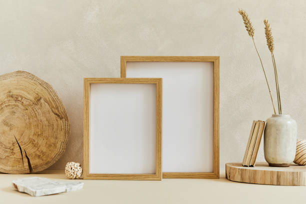 istock Stylish composition of cozy interior design with mock up poster frame, natural materials as wood and marble, dry plants and personal accessories. Neutral beige colors, template. 1347215998