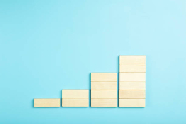 istock Business growth, development plan concept and business analytics background. Wooden steps of blocks on a blue background as financial and career growth, increase in monetary income and economic development. 1347216049