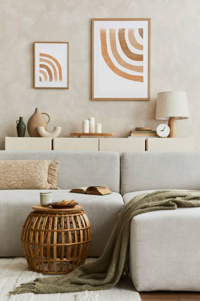istock Creative composition of stylish living room interior with mock up poster frame, sofa, commode clay vases and stylish personal accessories. Pastel neutral colors. Template. 1347218012