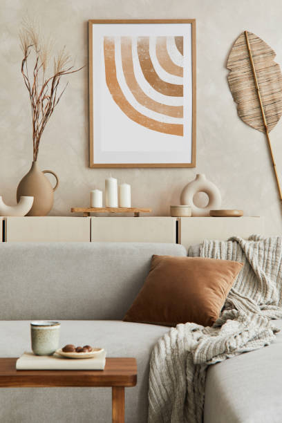 istock Elegant living room interior design with mock up poster frame, grey corner sofa, coffee table and personal accessories. Pastel neutral colors. Template. 1347218018