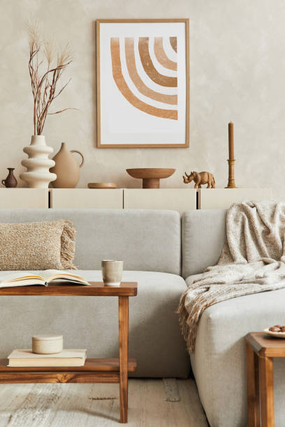 istock Elegant living room interior design with mock up poster frame, grey corner sofa, coffee table and personal accessories. Pastel neutral colors. Template. 1347218111
