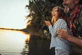 istock Proud grandfather helping out his granddaughter with fishing 1347219073
