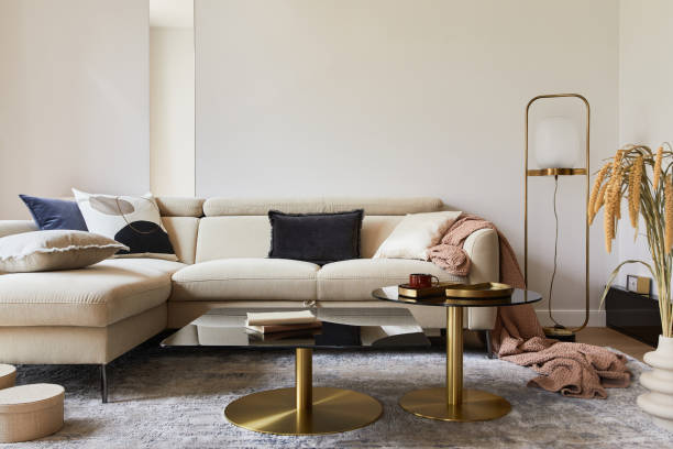 istock Creative living room interior composition with beige sofa, glass coffee table, carpet on the floor and glamorous accessories. Template. 1347220492