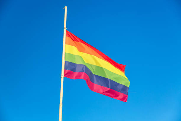 istock Rainbow flag LGBT movement symbol against blue sky background 1347221743