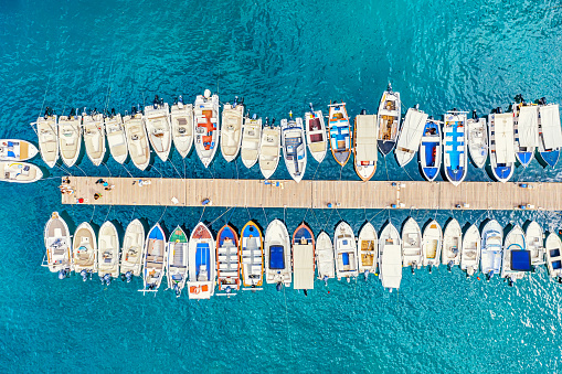 Aerial view of the boats and yachts on sea coast with transparent blue water. Paleokastritsa, Corfu Island, Greece.