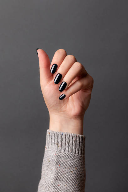 istock Female hand with black nails 1347222339