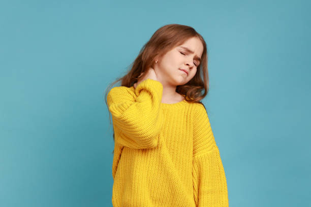 ritratto di bambina che massaggia la schiena dolorosa, senti disagio al collo, stile di vita sedentario del bambino. - human spine backache pain back foto e immagini stock