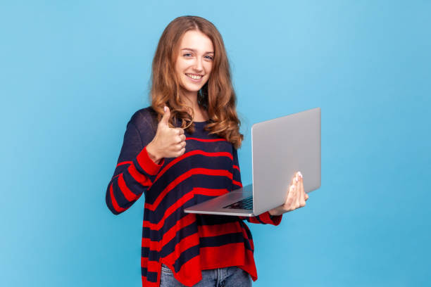 istock Woman holding notebook and showing thumb up, freelancer being satisfied with her work online. 1347229340