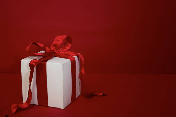 istock Gift box with red ribbon on red background 1347229504