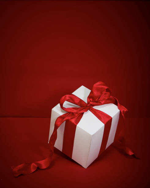 istock Gift box with red ribbon on red background 1347229517