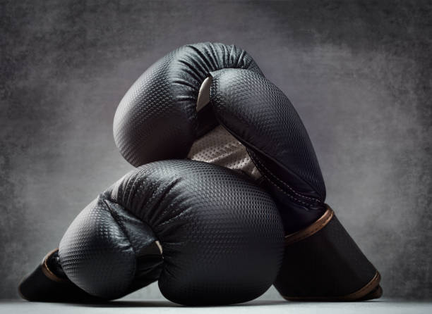 paire de gants de boxe sur fond de béton dans un environnement sombre - boxing glove sports glove isolated old photos et images de collection
