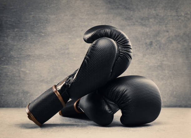 istock Pair of boxing gloves on concrete background in a dark environment 1347230174
