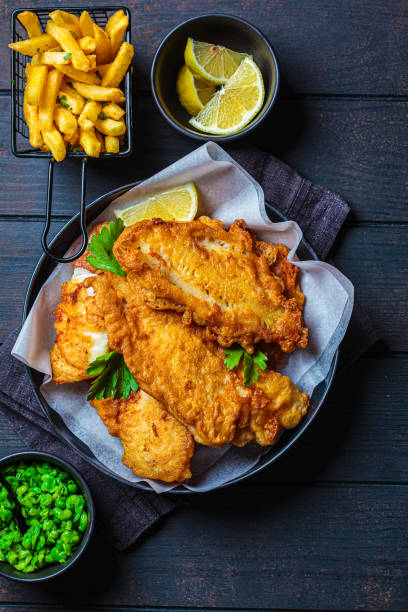 istock Fish and chips with green peas on dark background. British cuisine concept. 1347231279