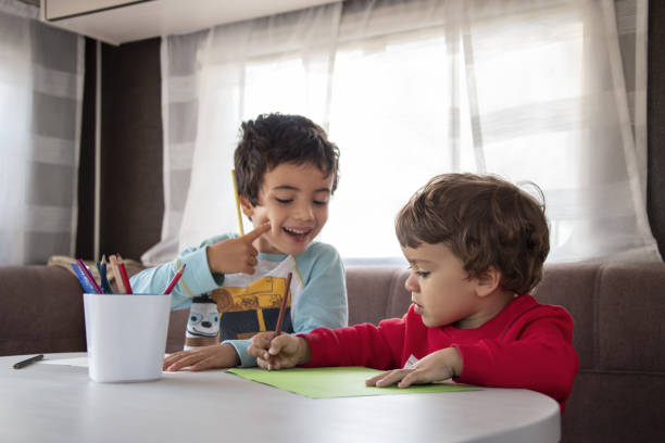 istock two Caucasian boy paints inside caravan on weekend trip. 1347232771