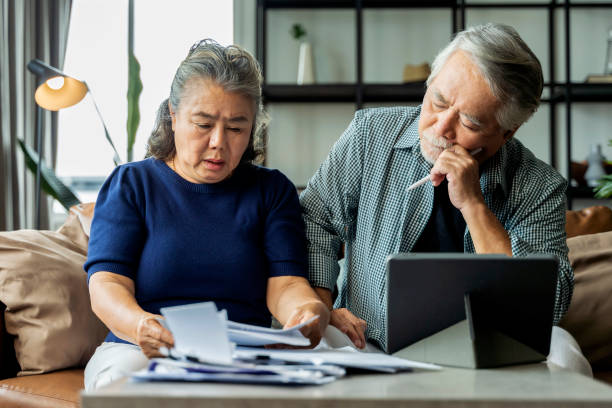 serious stressed asian senior old couple worried about bills discuss unpaid bank debt paper, sad poor retired family looking at tablet counting loan payment worry about money problem - retirement 401k planning document imagens e fotografias de stock