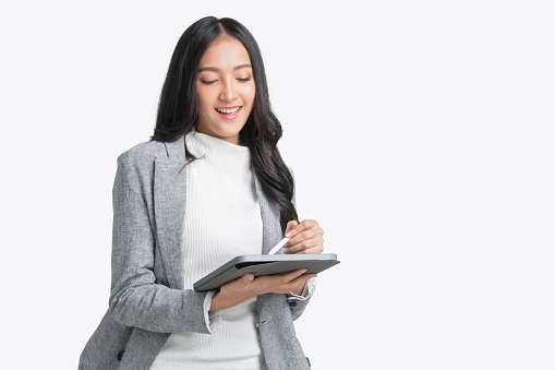 portrait of smart casual business woman asian female black long straight hair hand working with tablet technology device isolate white background studio shot