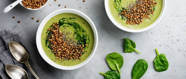 istock Useful smoothies from spinach with buckwheat flakes in ceramic bowls on gray concrete table background. Selective focus. Top view. Copy space 1347233830