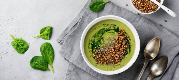 istock Useful smoothies from spinach with buckwheat flakes in ceramic bowls on gray concrete table background. Selective focus. Top view. Copy space 1347233842