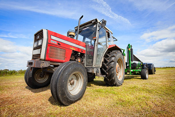 istock tractor collecting a roll of haystack in the field 134723438