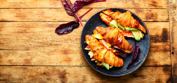 Fresh croissants with meat and fish Croissants with salted filling.Croissants with salmon, bacon, figs and cucumber.Space for text twisted bacon stock pictures, royalty-free photos & images