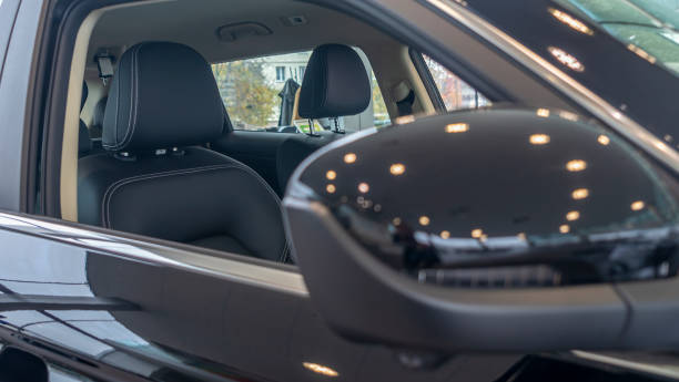 istock Close-up front view of rearview mirror and modern car interior. A rear view mirror on a car door. 1347235049