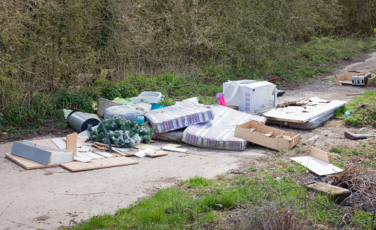 Illegal fly tipping or fly dumping. Garbage or waste dumped on a country lane, UK