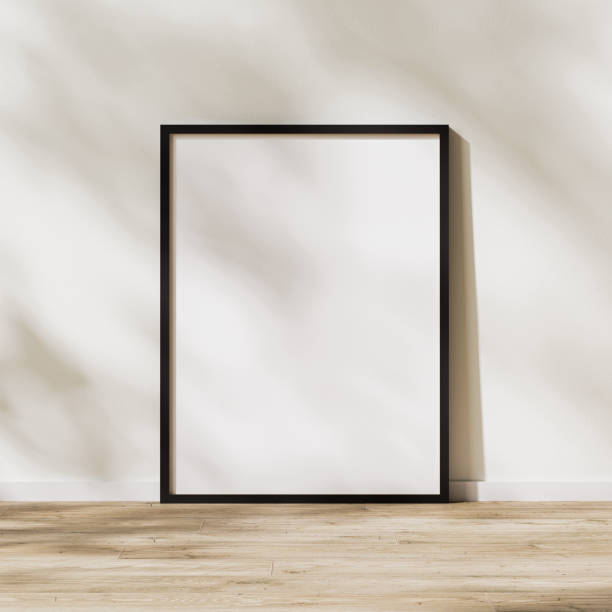 istock blank vertical black frame mock up, poster frame on wooden floor with sunlight with leaves shadow on white wall, 3d rendering 1347238358