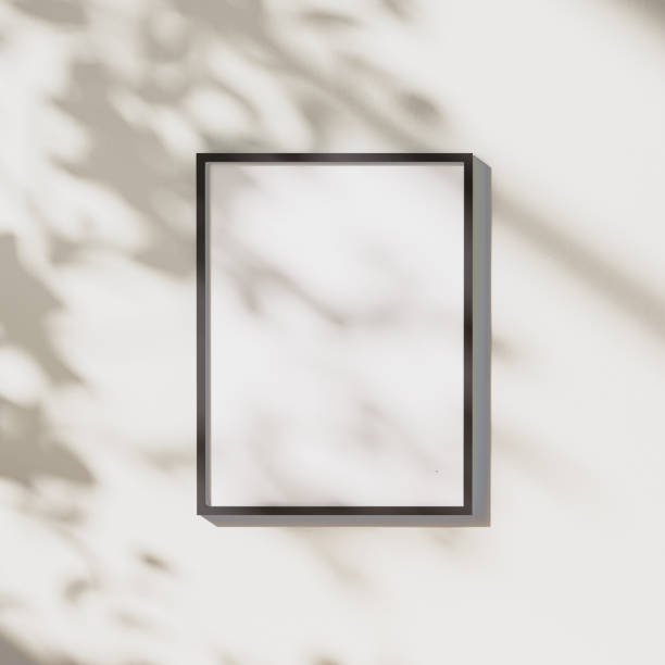 istock blank black vertical frame mock up with leaves shadows and sunlight on white wall background, 3d rendering 1347238359