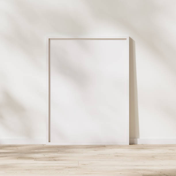 istock blank white frame mock up, poster frame on wooden floor with sunlight with leaves shadow on white wall, 3d rendering 1347238388