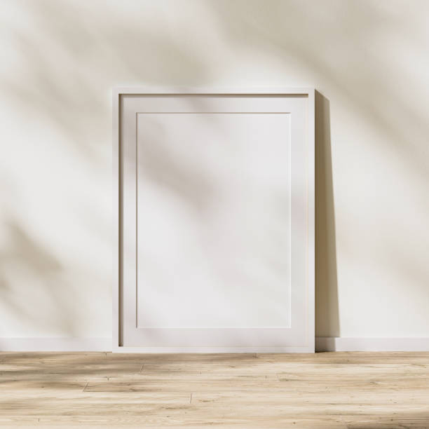 istock blank white frame with mat mock up, poster frame on wooden floor with sunlight with leaves shadow on white wall, 3d rendering 1347238389