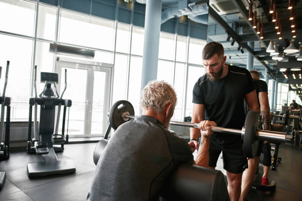 istock Professional trainer carefully choosing workout activities for aged man 1347239558
