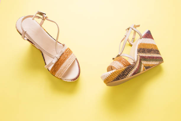 istock Female summer sandals on a yellow background close-up 1347239606