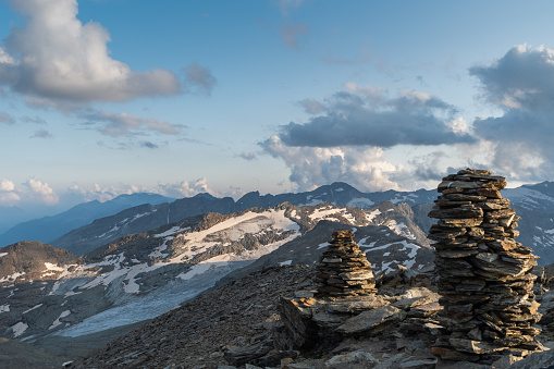 Vals, Switzerland, August 21, 2021 Stone heap at the summit of the mount Fanellhorn with a fascinating view over the alps