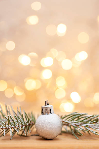 New Year's ball and spruce branches on a bokeh background. Vertical photo.
