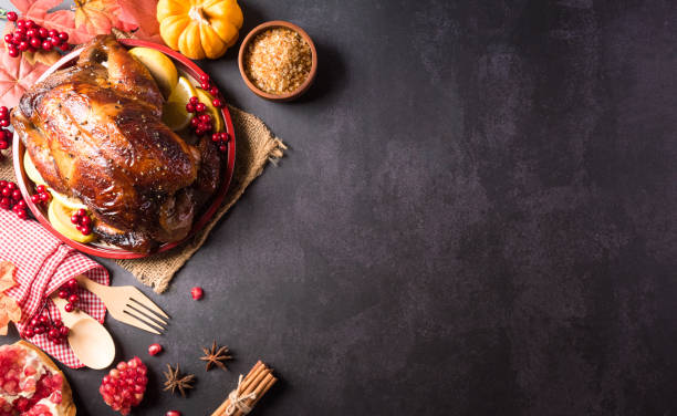 istock Thanksgiving dinner background concept with turkey roasted and all sides dishes, fall leaves, pumpkin and seasonal autumnal decor on dark stone background, top view, copy space. 1347242591