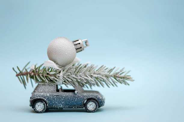 istock Christmas tree on a toy car on a blue background. 1347242729