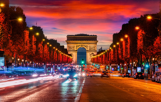 Illuminated Champs Elysee and view of Arc de Triomphe in parisian evening, France