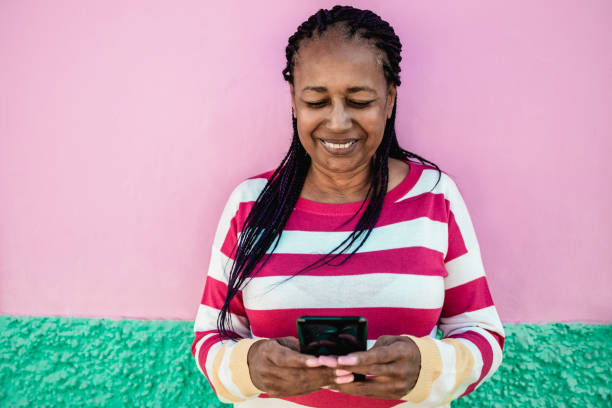 istock African senior woman using mobile phone outdoor - Focus on face 1347244598