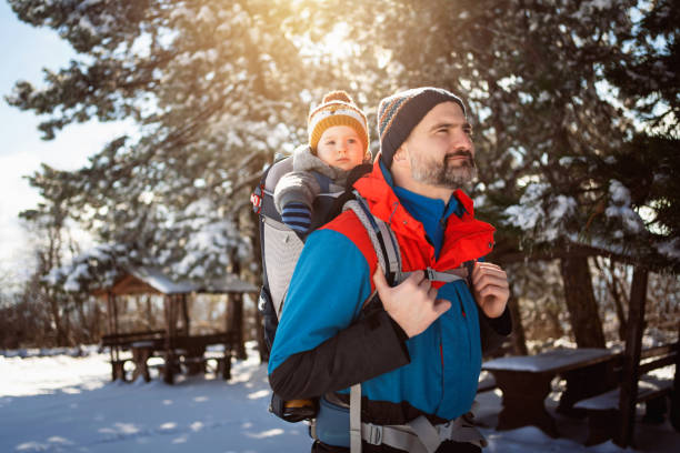 istock Caucasian son and father, hiking through snowy mountain forest 1347245236