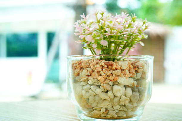 Close-up artificial flowers in clear glass on the table
